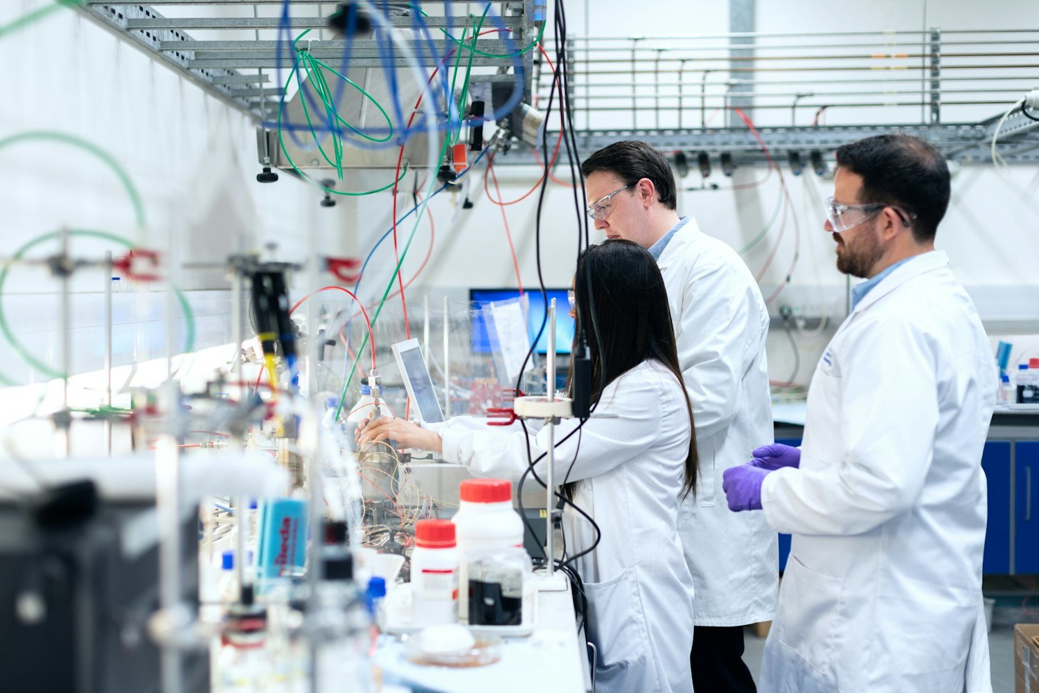 Scientists operating equipment in an export-grade pharmaceutical clean room